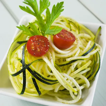 spaghetti di zucchine con due pomodorini, prezzemolo e una macinata di pepe